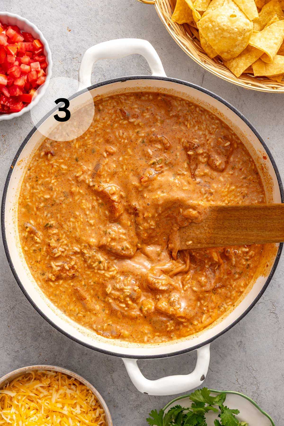 Stirring uncooked rice with chicken, seasonings and liquid.