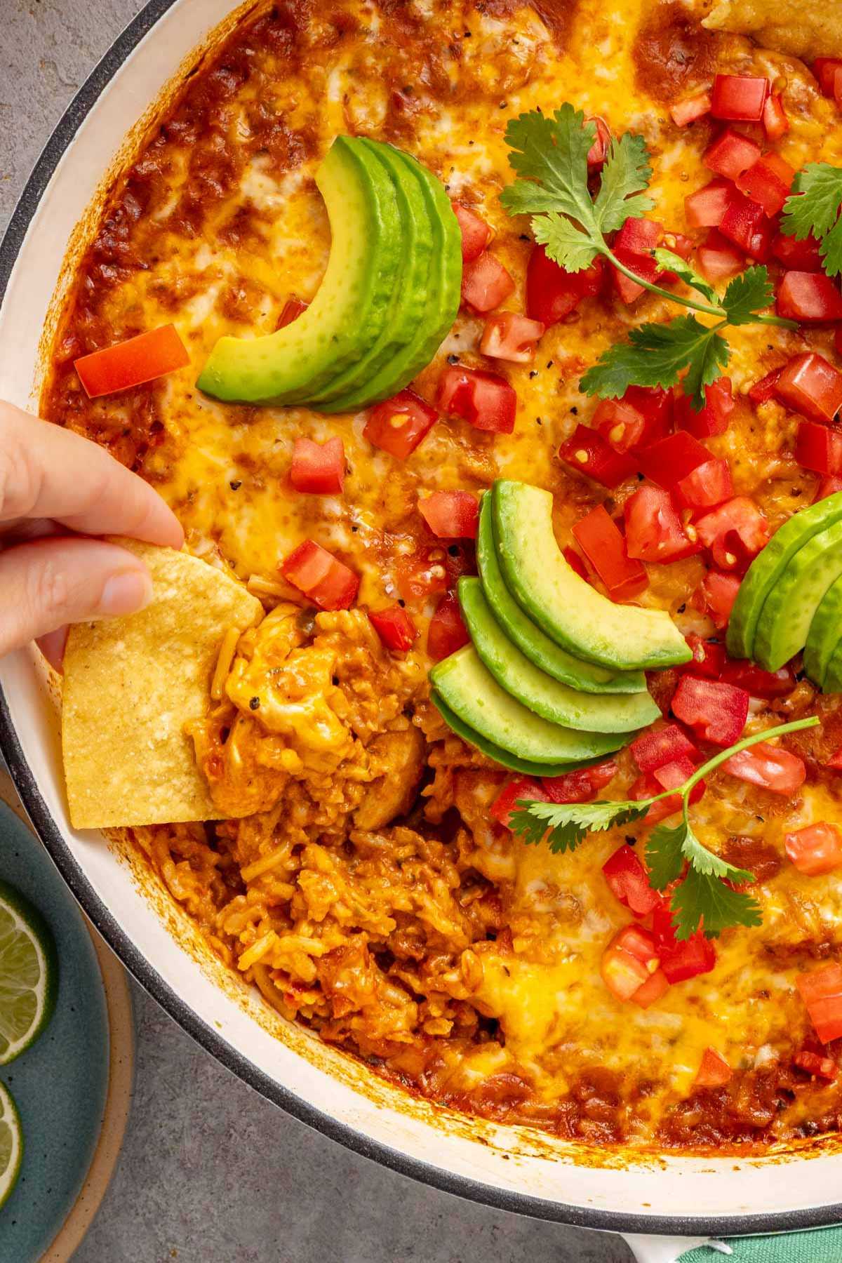 Using chips to scoop Mexican chicken and rice.