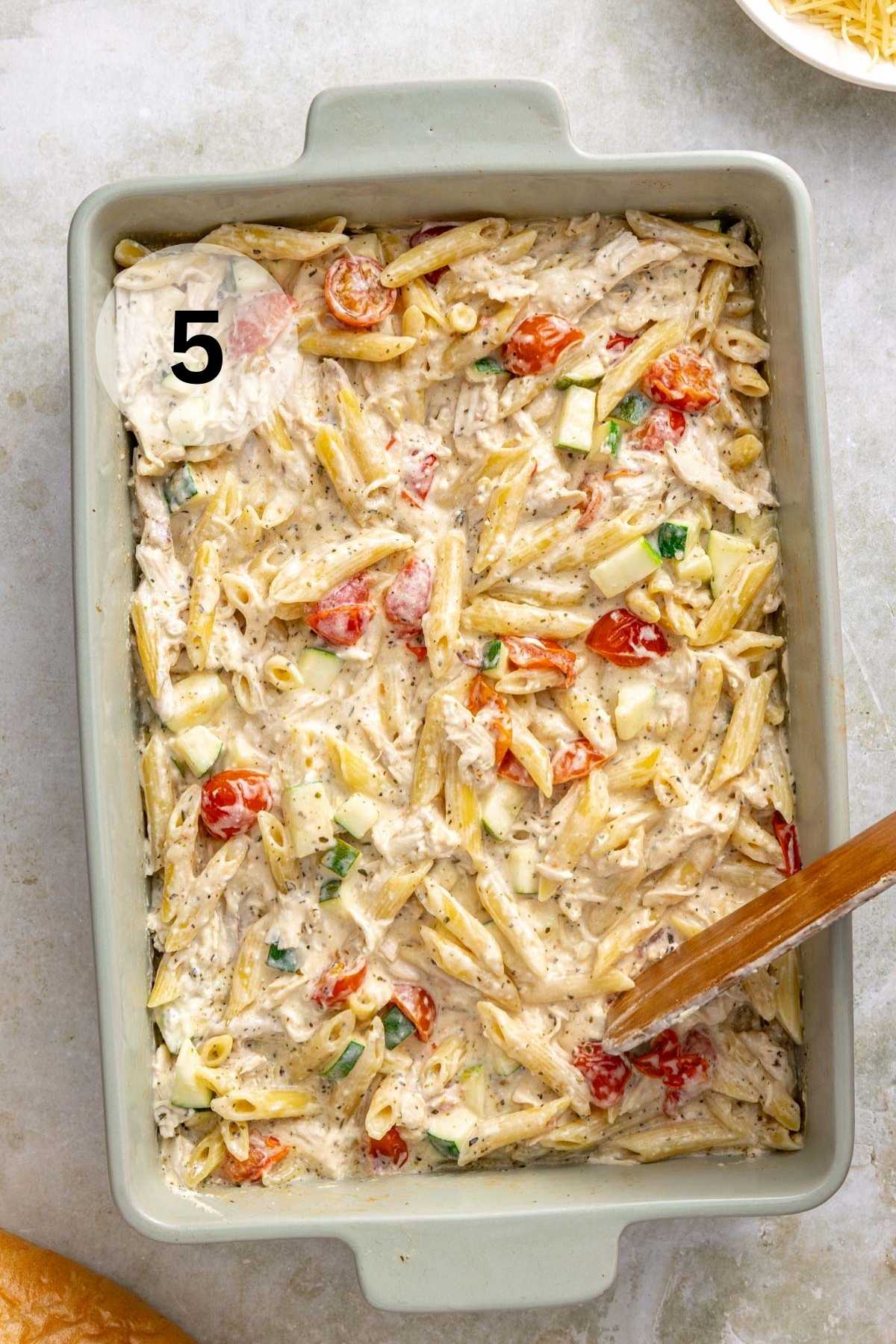 Stirring melted cream cheese into chicken and pasta dish.