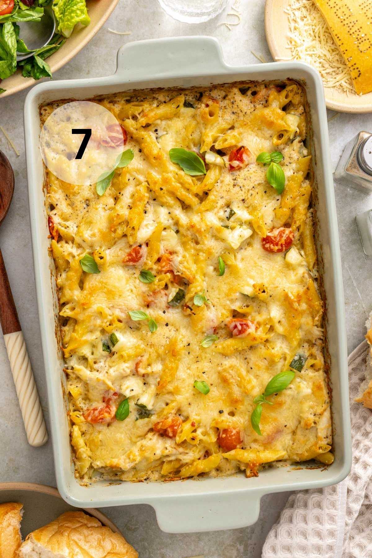 Baked chicken pasta bake garnished with fresh basil.