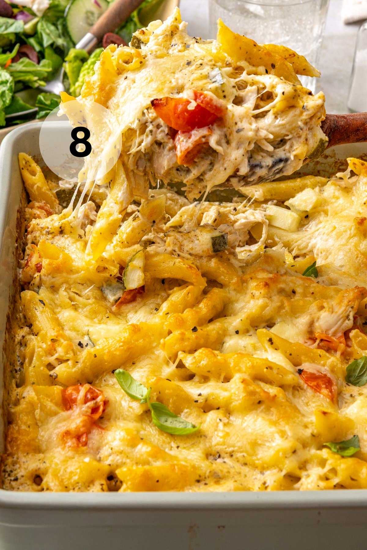 Scooping out a serving of baked creamy pasta and chicken.