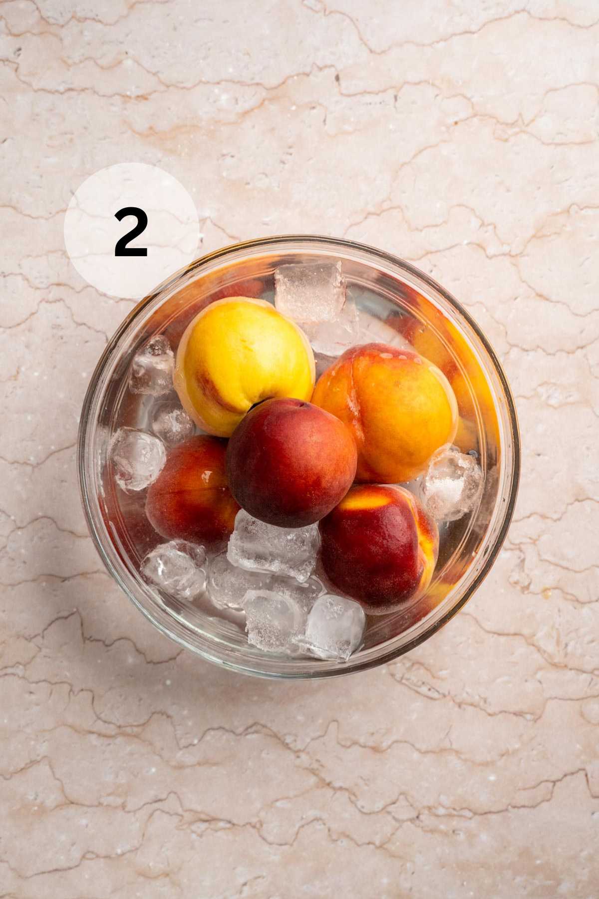 Peaches in a bowl filled with ice.