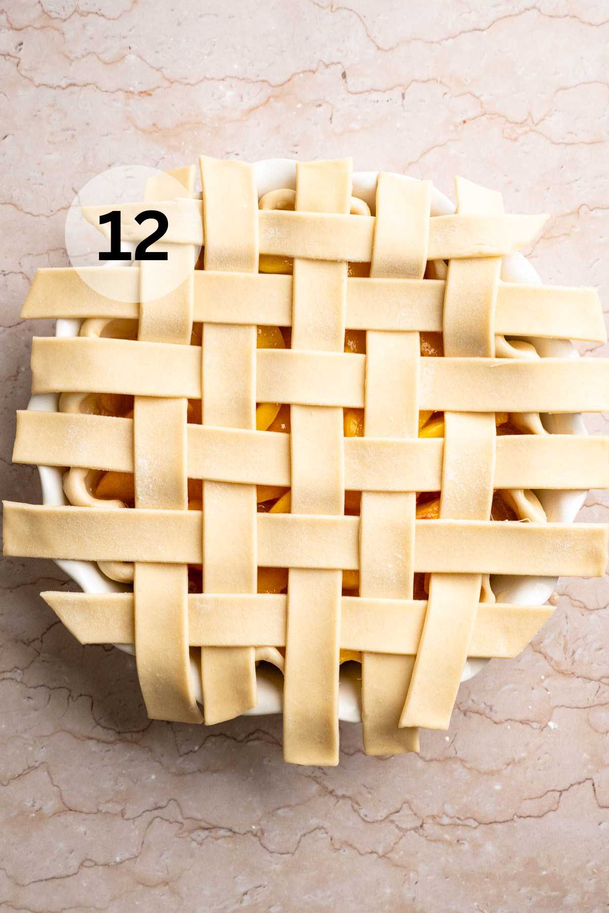 Lattice crust assembled on top of a peach pie.