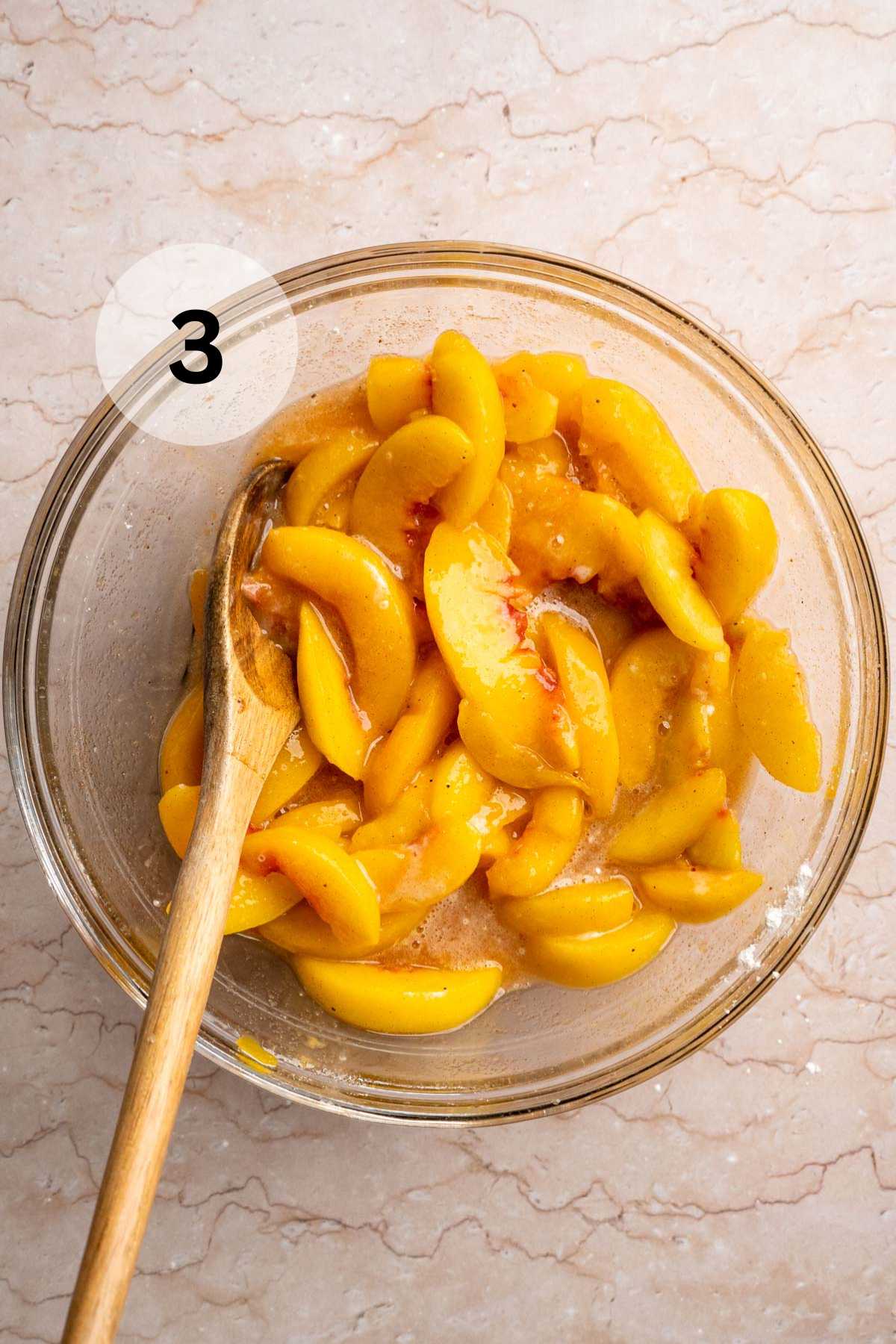 Stirring peach slices with cornstarch and spices.