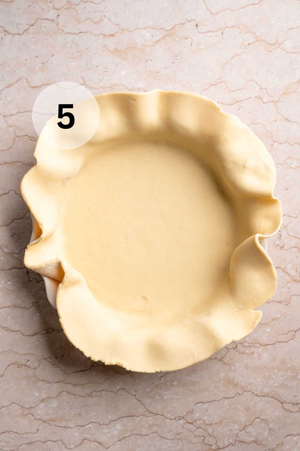 Pie crust in the bottom of a pie plate.
