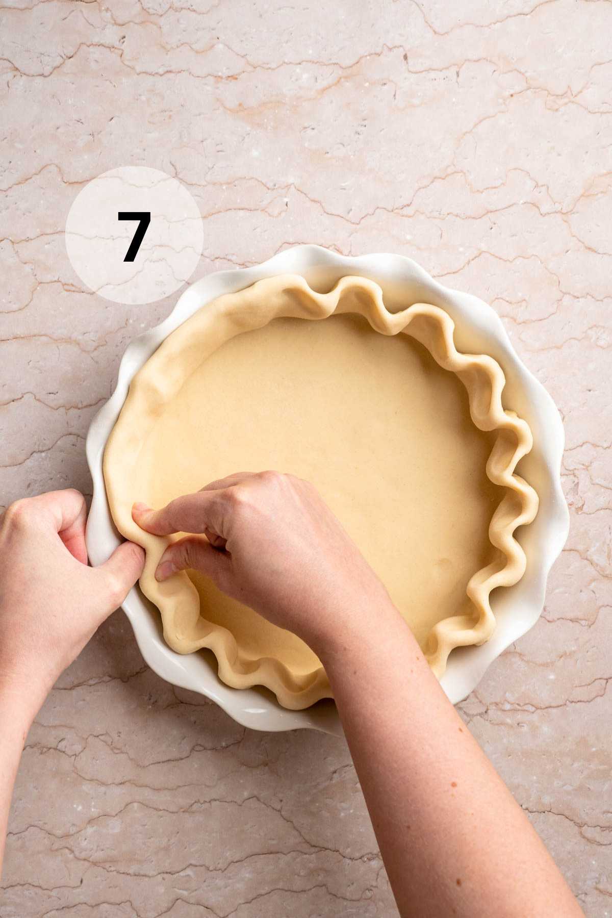 Showing the process of fluting the edges of a pie crust.