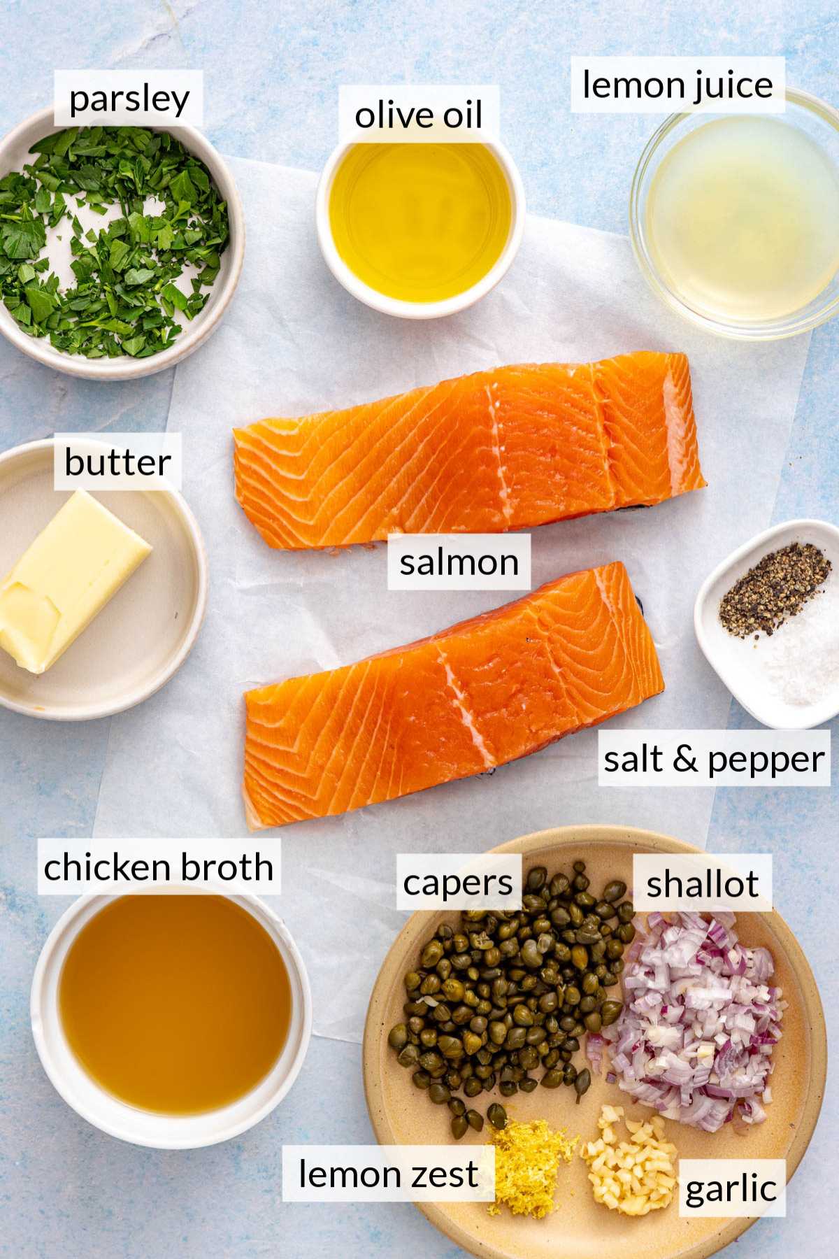 Salmon fillets near small bowls with butter, chicken broth, lemon juice and olive oil.