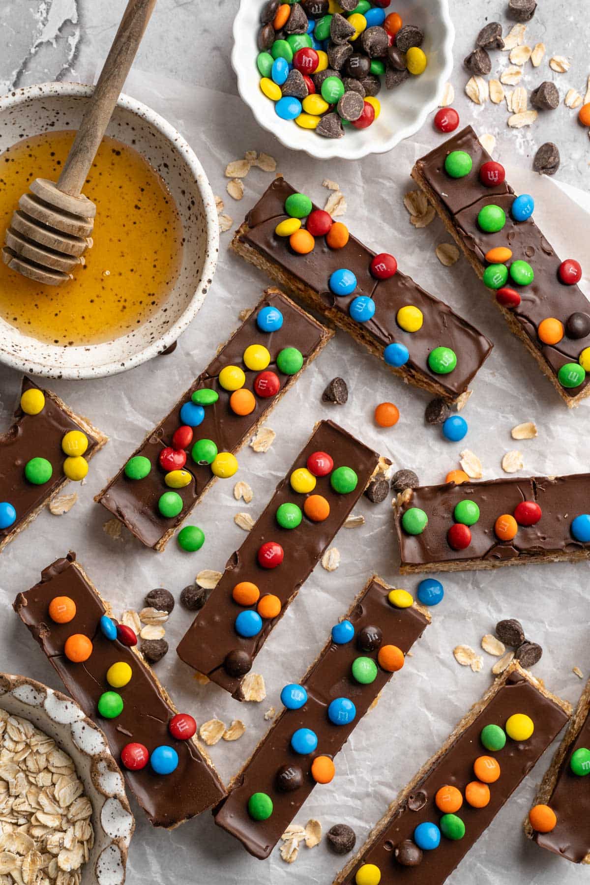 Homemade protein bars topped with a layer of chocolate and M&M's.