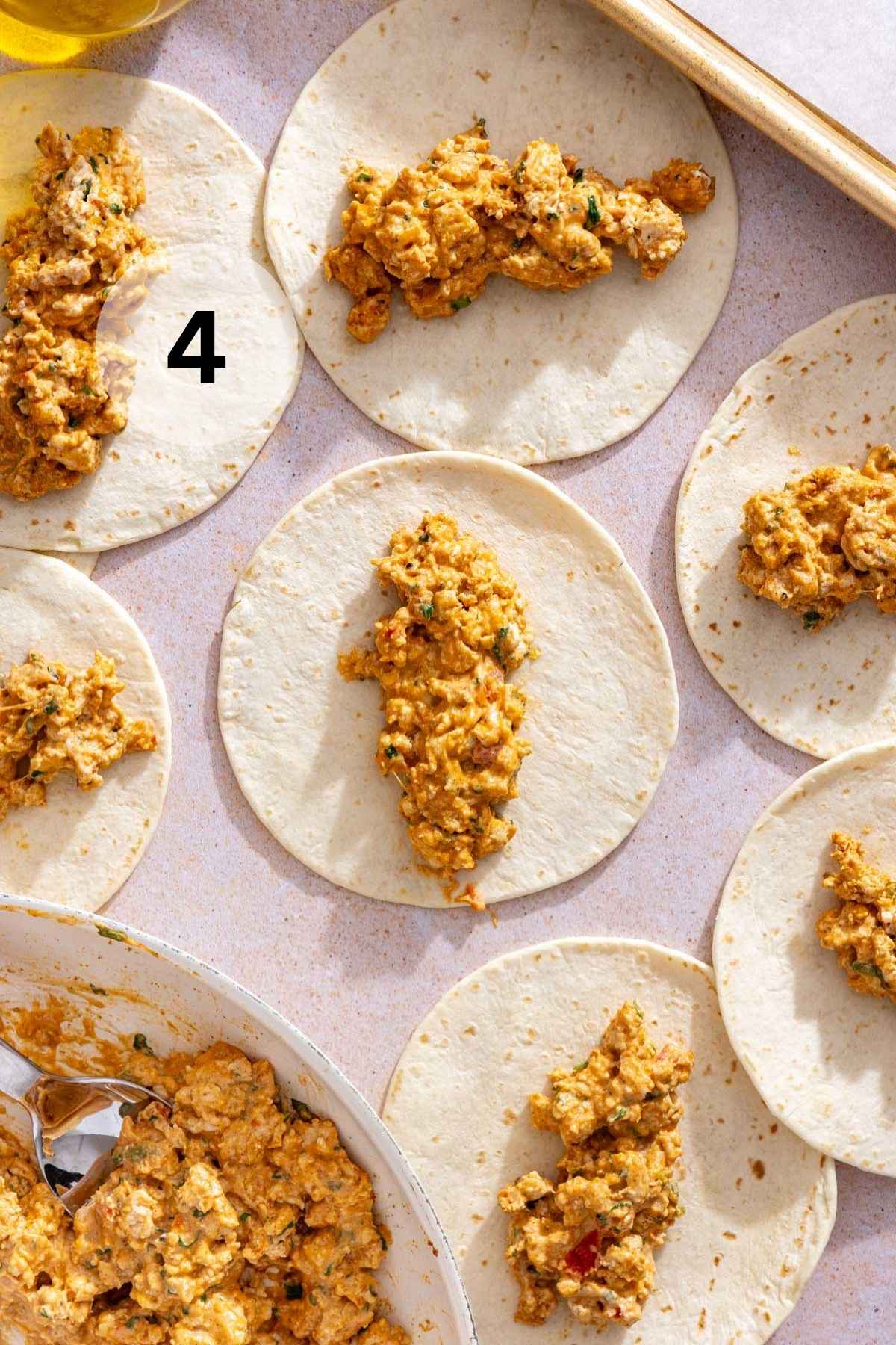 Adding filling down the center of small tortillas.