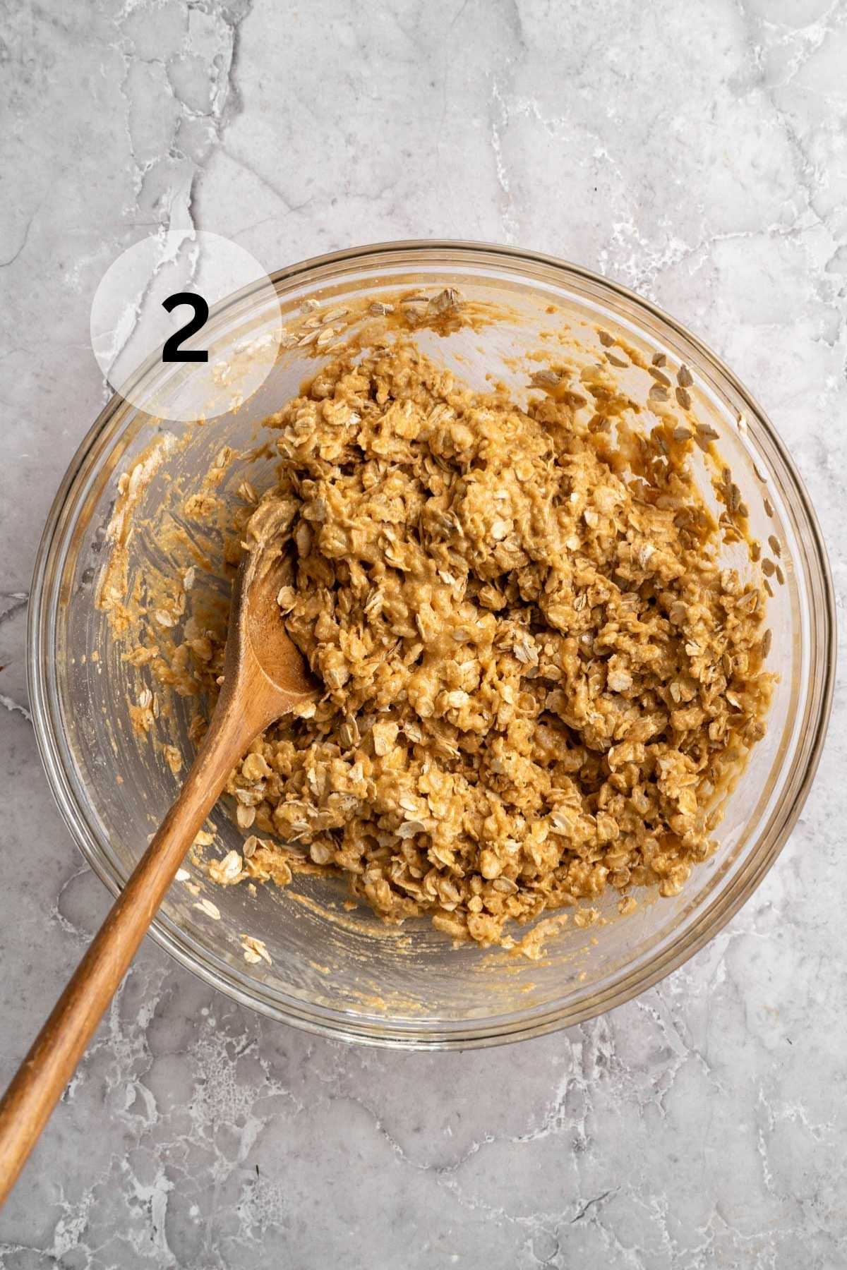 Stirring oats and rice krispies into peanut butter mixture.