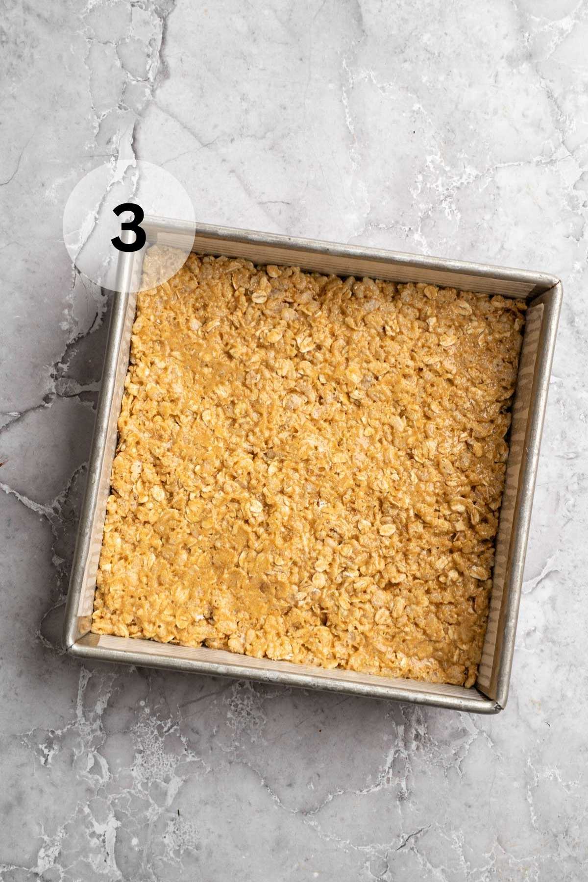 Protein bar mixture spread in a square pan.