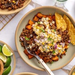 Sweet potato bowls topped with street corn and served with tortilla chips.