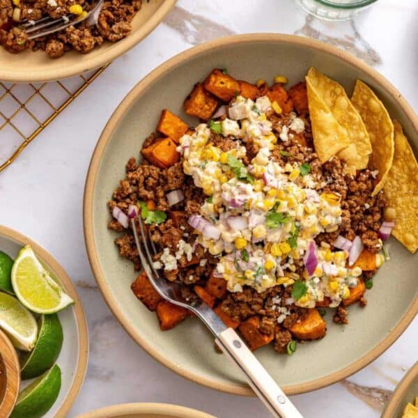 Sweet potato bowls topped with street corn and served with tortilla chips.