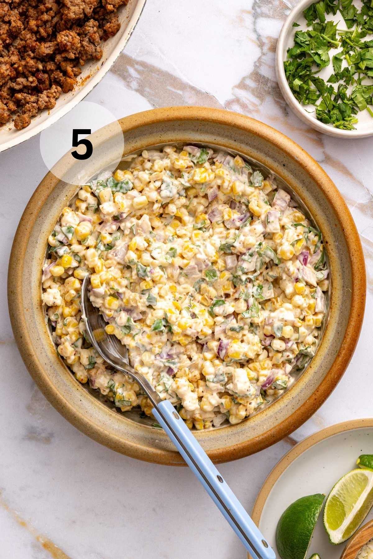 Stirring corn with mayo and sour cream.