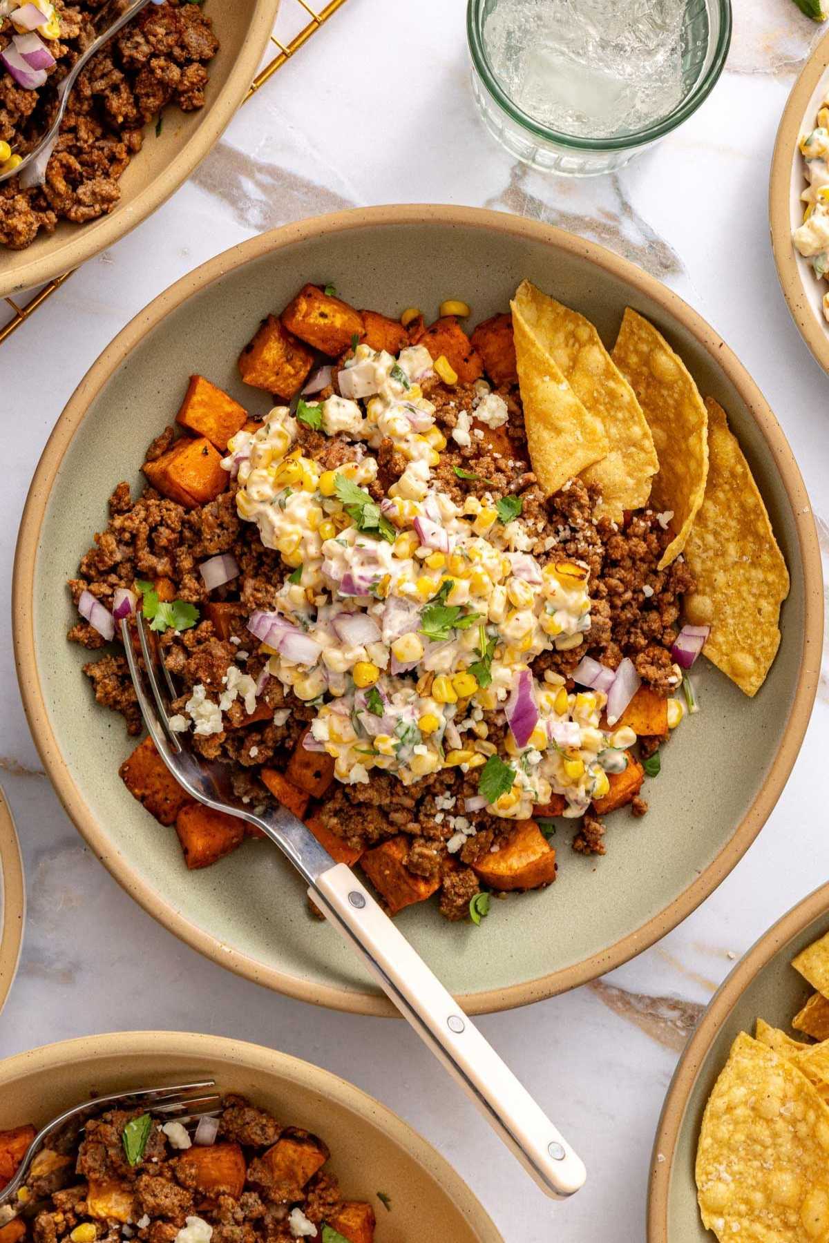Sweet potato ground beef bowls topped with a street corn mixture.