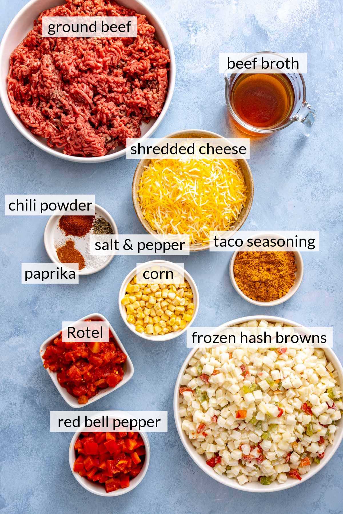 Bowls with raw ground beef, frozen potatoes, shredded cheese, spices and taco seasoning.