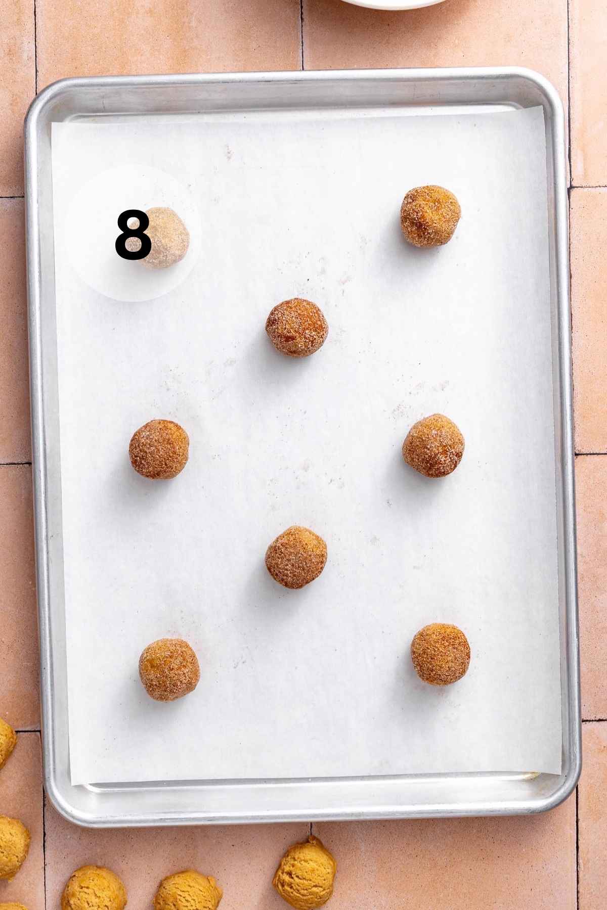 Cookie dough balls on a baking sheet.