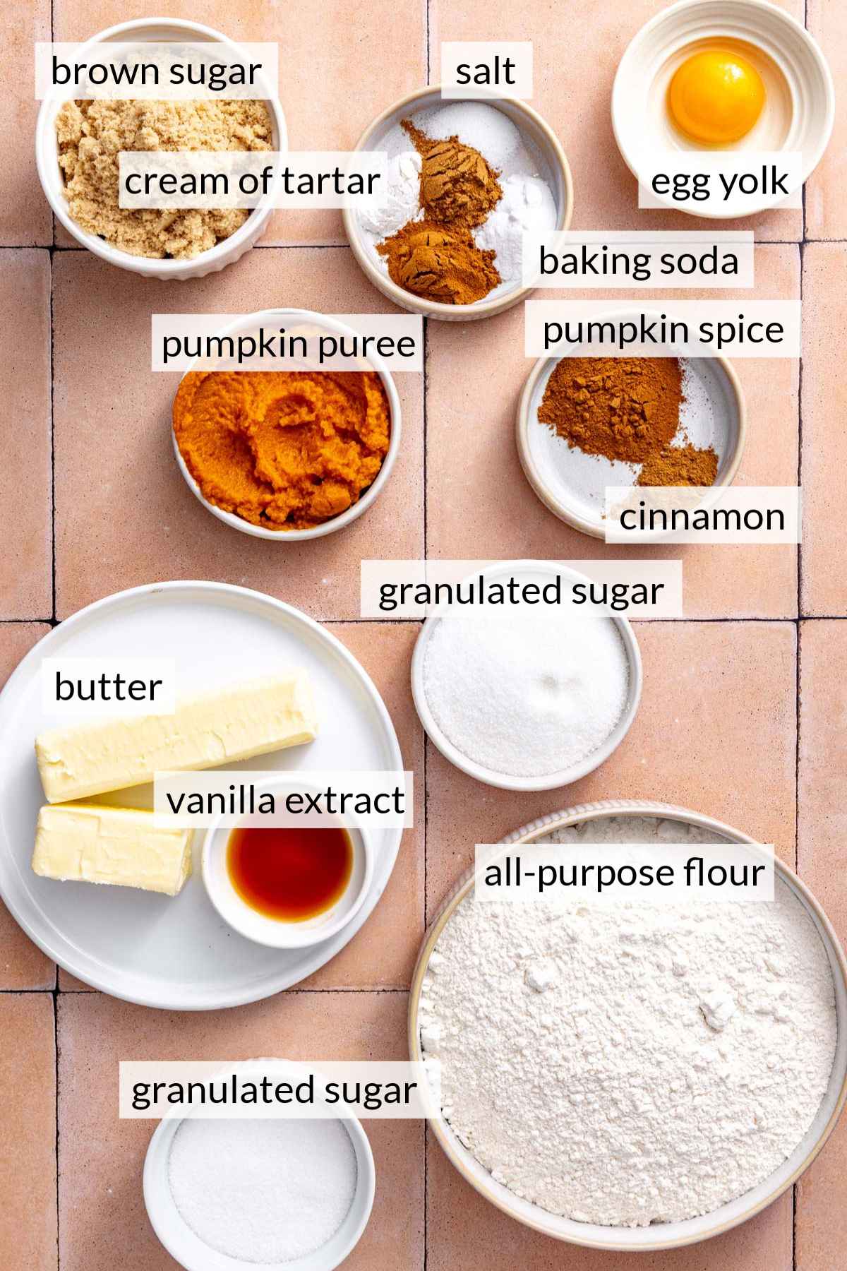 Small bowls with flour, butter, sugar, pumpkin, and spices.