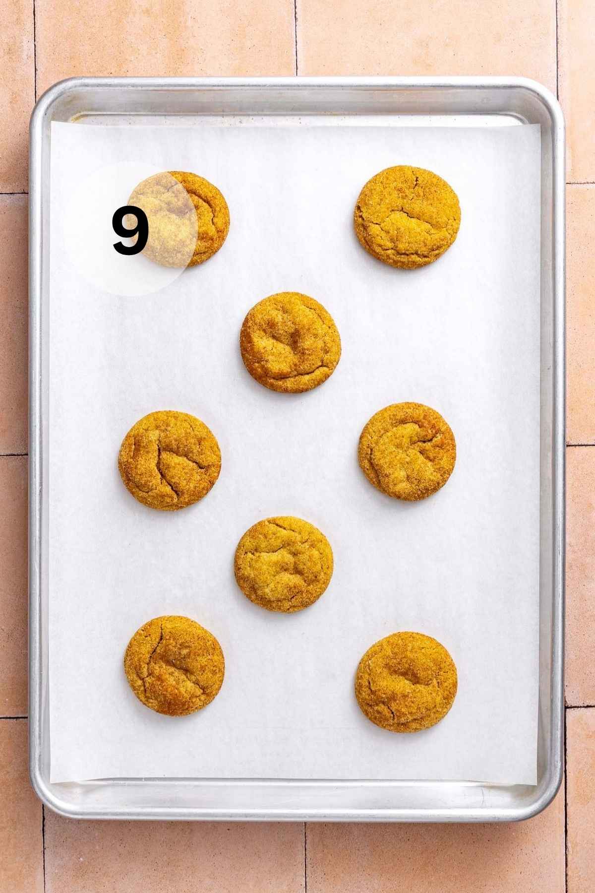 Baked pumpkin snickerdoodle cookies on a baking sheet.