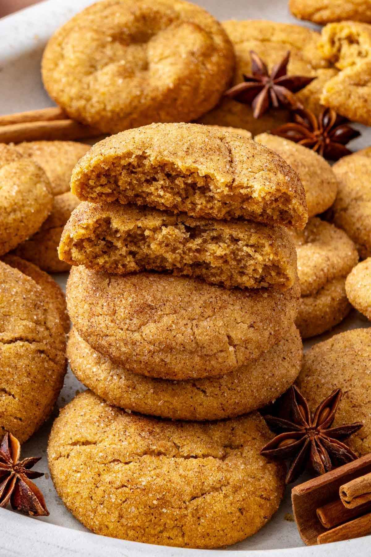 Pumpkin snickerdoodles stacked with top ones cut in half.