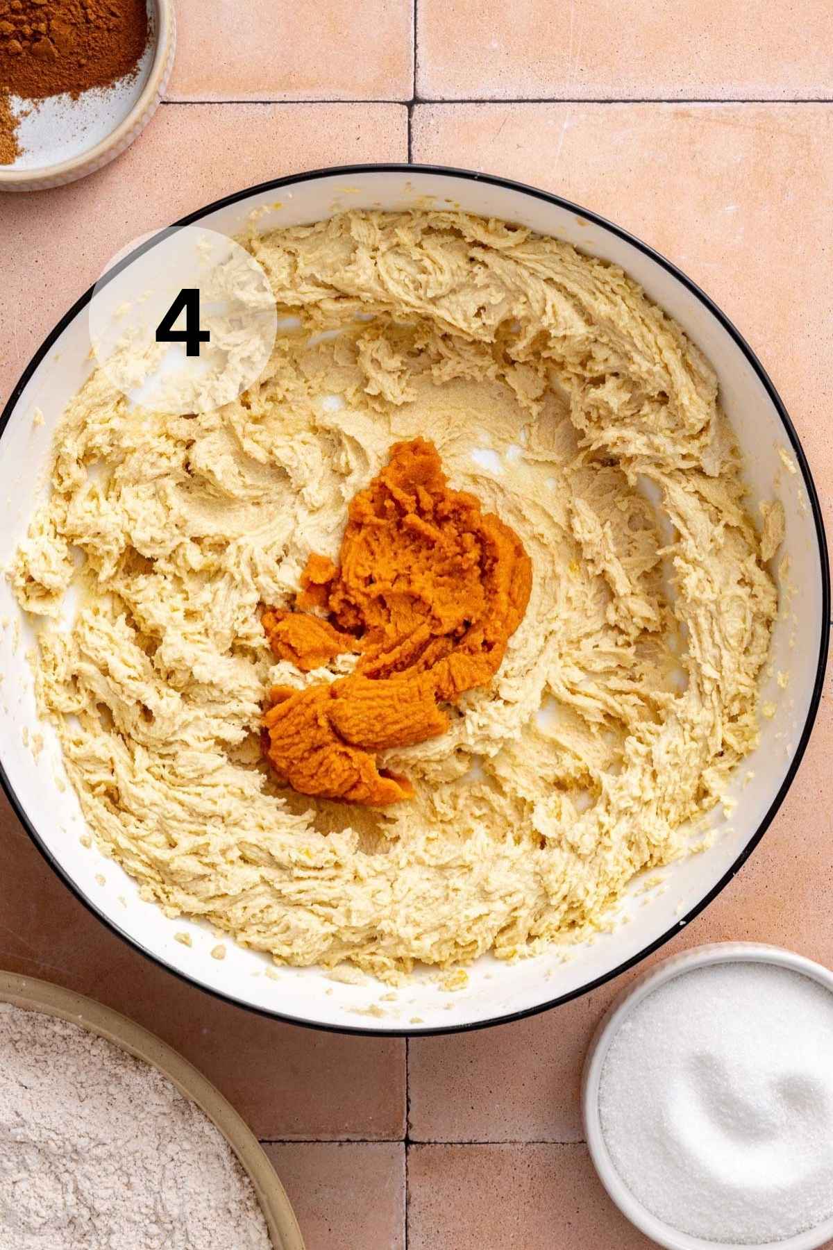 Adding pumpkin puree to cookie dough.